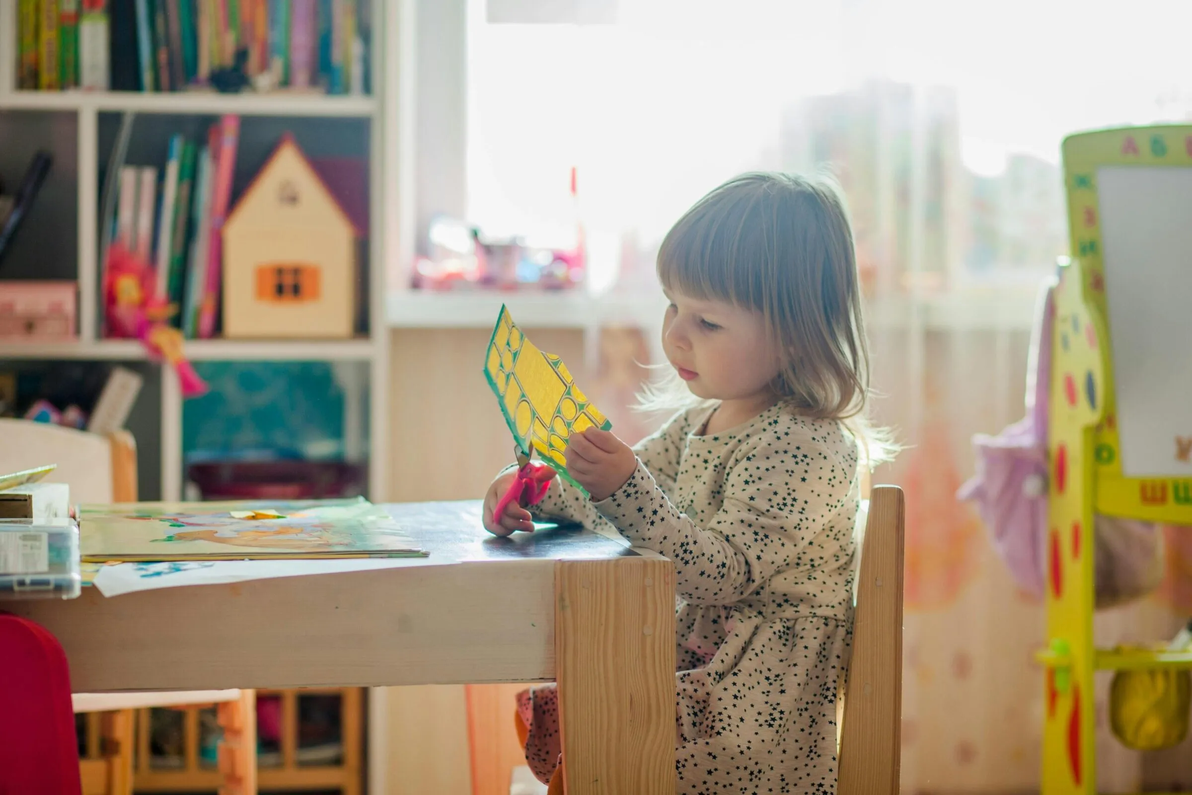 Preschooler cutting paper during a craft activity