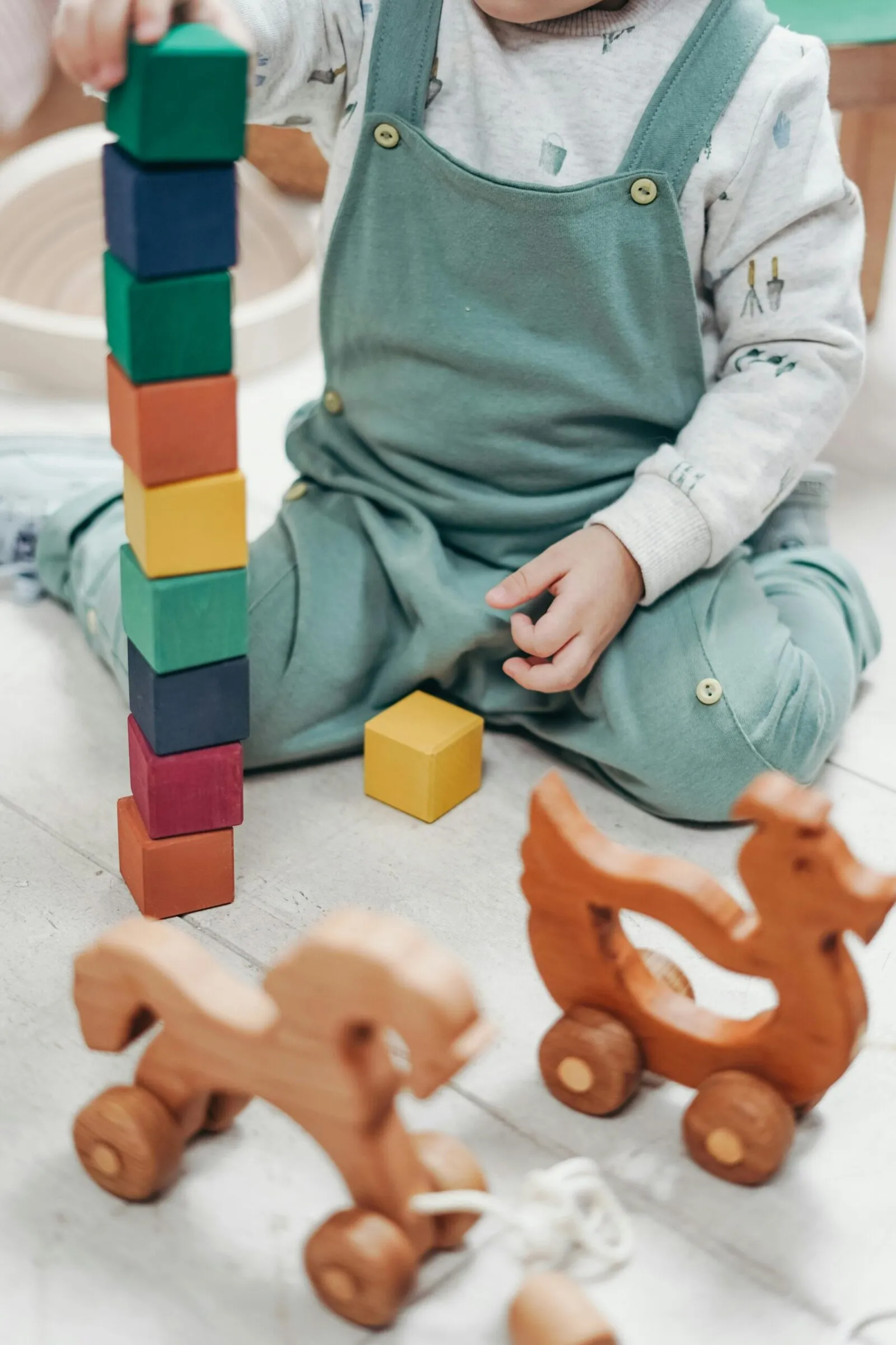 Toddler stacking colorful wooden blocks